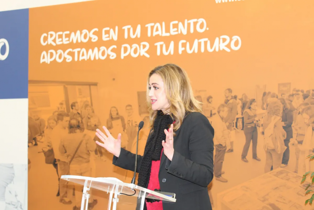 Fotografía en la que se puede ver a la primera teniente de alcalde del Ayuntamiento de La Rinconada, Raquel Vega al micrófono