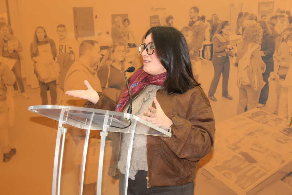 Fotografía en la que se puede ver a La delegada territorial de Inclusión Social, Juventud, Familias e Igualdad en Sevilla, Mª Luisa Cava al micrófono